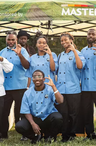 Volunteers of a nonprofit pose in front of a pop-up tent